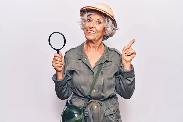 Senior Mulher Cabelos Grisalhos Usando Chapéu Explorador Segurando Lupa Sorrindo — Fotografia de Stock