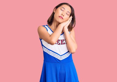 Genç, güzel Çinli kız amigo kız üniforması giyip uyuyordu. Yorgundu, hayal kuruyordu. Elleriyle poz veriyordu, gözleri kapalıydı.. 