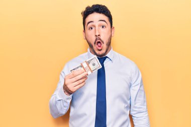 İş kıyafetleri giymiş genç İspanyol bir adam elinde dolar tutuyordu. Korkmuş ve ağzı açık bir şekilde şaşırmıştı. Şaşırmış gibiydi. 