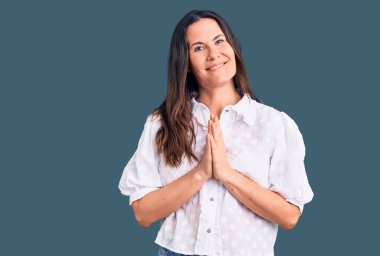 Genç, güzel, esmer bir kadın. Sıradan bir gömlek giyiyor. Elleriyle dua ediyor, af diliyor.. 