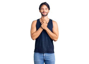 Yakışıklı, sıradan kıyafetler giyen, göğsünde elleri kapalı, yüzünde minnet ifadesi olan yakışıklı bir İspanyol. sağlık kavramı. 