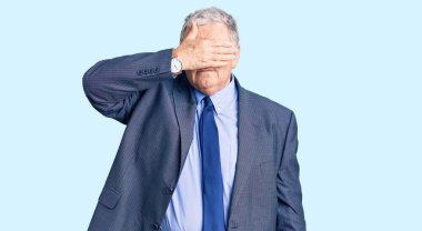 Yaşlı, gri saçlı, iş ceketi giyen, gözlerini kapayan, ciddi ve üzgün görünen bir adam. Görme, saklama ve reddetme konsepti 