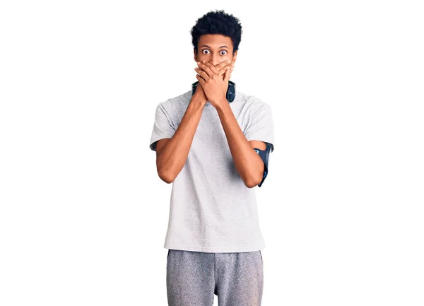 Young African American Man Wearing Gym Clothes Using Headphones Shocked — Stock Photo, Image