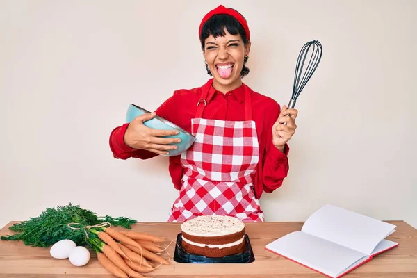 Piękna Brunetka Kobieta Gotowanie Ciasto Marchewkowe Pomocą Trzepaczki Wystający Język — Zdjęcie stockowe