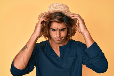 Stres yüzünden başı ağrıyan yaz şapkası takan İspanyol bir genç. migren ağrısı. 