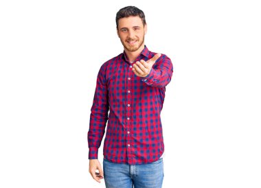 Ayı gömleği giyen yakışıklı genç adam gülümseyen neşeli bir el uzatıyor ve kabul ediyor.. 