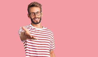 Sakallı, sıradan kıyafetler ve gözlüklü, neşeli gülümseyen, yardım eli uzatan ve kabul gören yakışıklı sarışın adam.. 