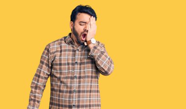 Latin asıllı genç bir adam günlük kıyafetler giyiyor. Yarı yüzünü, göz ve ağzını eliyle kapatmaktan yoruluyor. Yüzüm acıyor.. 