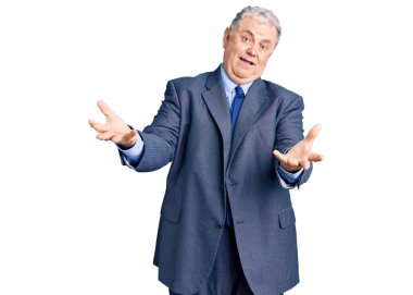 İş ceketi giyen, kıdemli, gri saçlı adam gülümseyen, yardım eli uzatan ve kabul gören.. 