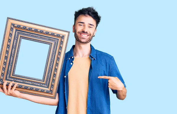 Junger Hispanischer Mann Mit Leerem Rahmen Zeigt Mit Dem Finger — Stockfoto