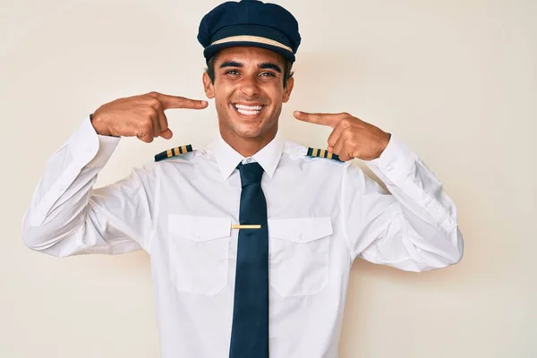 Junger Hispanischer Mann Flugzeugpilotenuniform Fröhlich Lächelnd Und Mit Fingern Zähne — Stockfoto