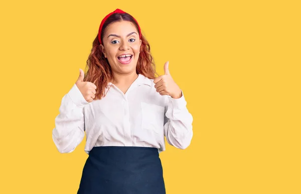 Junge Lateinische Frau Trägt Kellnerschürze Erfolgszeichen Tut Positive Geste Mit — Stockfoto