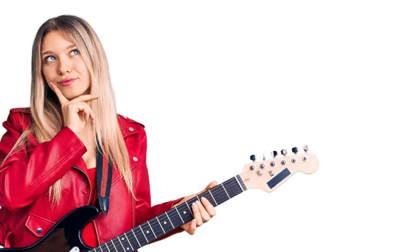 Young Beautiful Blonde Woman Playing Electric Guitar Serious Face Thinking — Stock Photo, Image