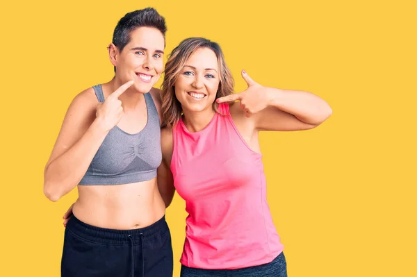 Par Mujeres Con Ropa Deportiva Sonriendo Alegre Mostrando Señalando Con — Foto de Stock