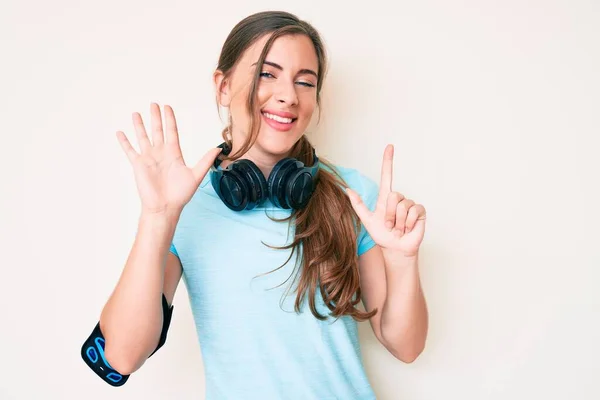 Schöne Junge Kaukasische Frau Turnbekleidung Und Mit Kopfhörern Zeigt Und — Stockfoto