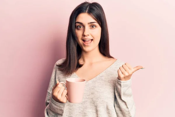 Junges Schönes Mädchen Trinkt Eine Tasse Kaffee Und Zeigt Mit — Stockfoto