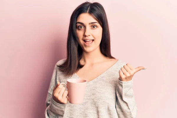 Menina Bonita Nova Bebendo Caneca Café Apontando Polegar Até Lado — Fotografia de Stock