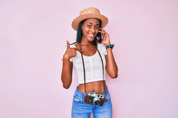 Joven Mujer Afroamericana Sosteniendo Cámara Vintage Hablando Teléfono Inteligente Apuntando —  Fotos de Stock