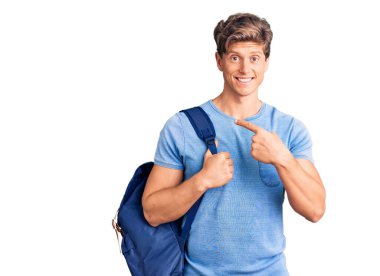 Sırt çantası tutan genç ve yakışıklı bir adam gülümsüyor. 