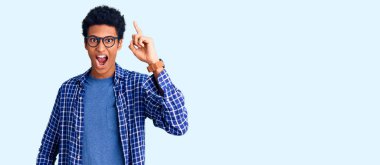 Sıradan kıyafetler giyen ve gözlüklü genç Afro-Amerikan adam başarılı bir fikri işaret ediyor. Heyecanlı ve mutlu. Bir numara.. 