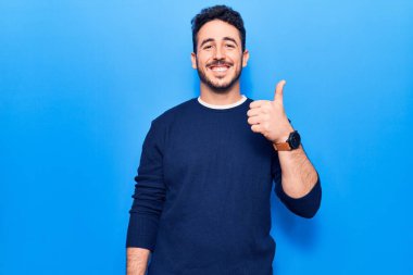 Neşeli ve pozitif gülümseyen İspanyol asıllı genç adam, mükemmel ve onay işareti yapıyor. 