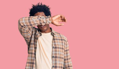 Afro saçlı, sıradan kıyafetler giyen ve gözlük takan, gözleri kollarıyla kaplayan, ciddi ve üzgün görünen yakışıklı Afro-Amerikalı bir adam. Görme, saklama ve reddetme konsepti 