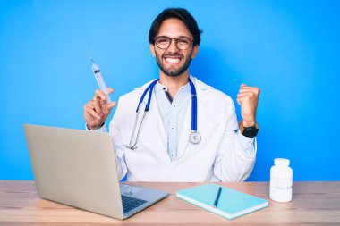 Klinikteki yakışıklı İspanyol doktor elinde şırıngayla gururla bağırıyor zaferi ve başarıyı kutluyor. 