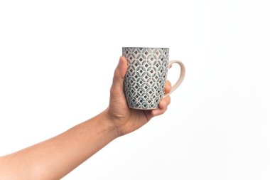 Beyaz arka planda bir fincan kahve tutan Kafkas delikanlısının eli