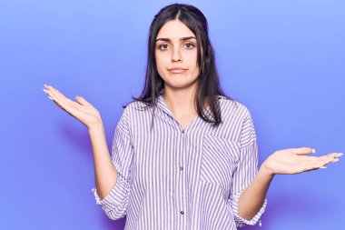 Sıradan çizgili tişört giyen genç ve güzel bir kız habersiz ve kolları açık, hiçbir fikrim yok ve şüpheli bir yüzüm var.. 