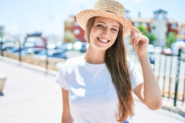 Genç sarışın kadın tatilde gülümsüyor. Mutlu bir şekilde caddede yürüyor.