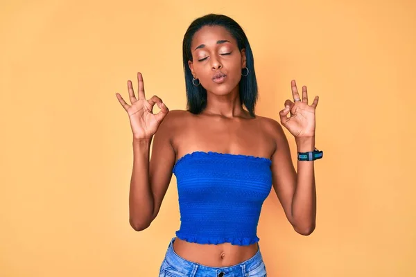身穿休闲装的年轻非洲裔美国女人 闭着眼睛 用手指做冥想动作 瑜伽概念 — 图库照片