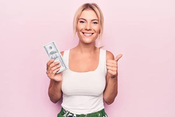 Junge Schöne Blonde Frau Hält Dollarnoten Über Isoliertem Rosa Hintergrund — Stockfoto