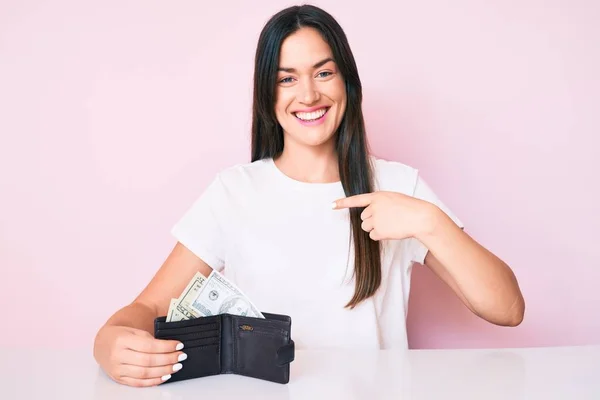 코카서스 여성은 지갑을 테이블에 지폐를 행복하고 자랑스럽게 미소짓는 자신을 가리키는 — 스톡 사진