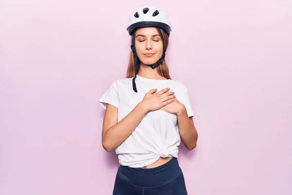年轻美丽的女孩戴着自行车头盔 双手放在胸前笑着 满脸感激地闭上眼睛 健康概念 — 图库照片