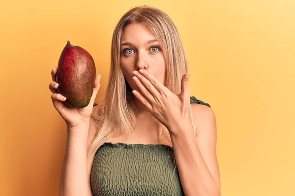 Sarışın Genç Bir Kız Mango Tutuyor Ağzını Eliyle Kapatıyor Şok — Stok fotoğraf