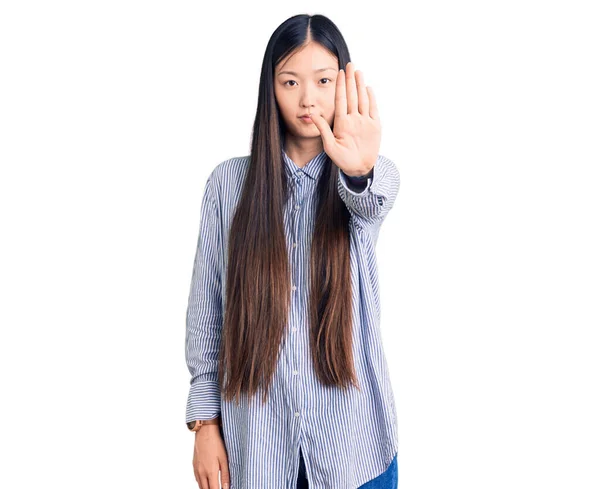 年轻美丽的中国女人穿着休闲装 手心手心停止歌唱 用消极而严肃的手势警告人 — 图库照片