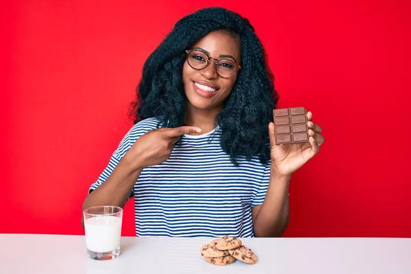 Mooie Afrikaanse Vrouw Die Een Chocoladereep Eet Een Glas Melk — Stockfoto
