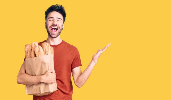 Young Hispanic Man Holding Paper Bag Bread Celebrating Victory Happy — Stock Photo, Image