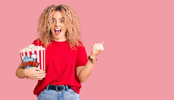 Jovem Loira Com Cabelo Encaracolado Comendo Pipoca Gritando Orgulhoso Celebrando — Fotografia de Stock