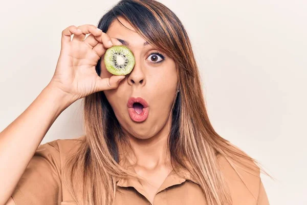 Joven Hermosa Mujer Sosteniendo Kiwi Sobre Ojo Asustado Sorprendido Con — Foto de Stock