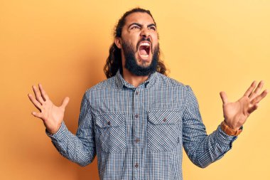 Genç Arap adam gündelik kıyafetler giyip deli gibi bağırıyor ve agresif bir ifade ve kollarla bağırıyor. hüsran kavramı. 