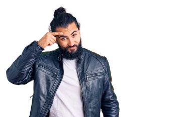 Sıradan deri ceket giyen genç bir Arap alnındaki sivilceden mutsuz, siyah noktalı çirkin bir enfeksiyon gösteriyor. sivilce ve deri problemi 