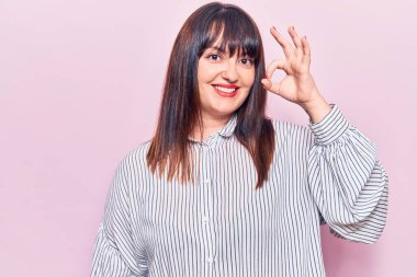 Gündelik kıyafetler giyen, gülümseyen, el ve parmaklarıyla 