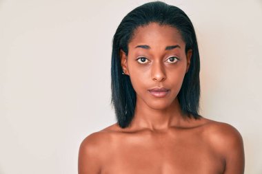 Genç Afrikalı Amerikalı kadın arka planda çırılçıplak. Düşünce tarzı ve ayık ifadesi. Kendine güvenen biri. 