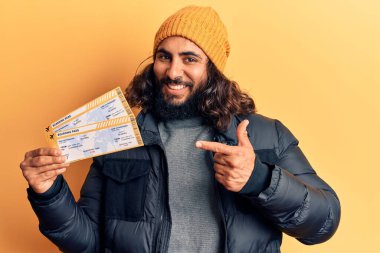 Biniş kartı tutan genç Arap adam mutlu mesut elini ve parmağını gösterdi. 