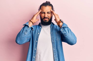 Genç Arap adam, elleri kafasında günlük giysiler giyiyor, stres yüzünden baş ağrısı çekiyor. migren ağrısı. 