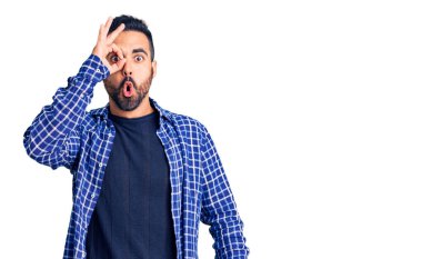 Gündelik kıyafetler giyen genç İspanyol adam şaşırmış yüz ifadesiyle şok olmuş, parmaklarından bakan gözler. İnançsız ifade. 