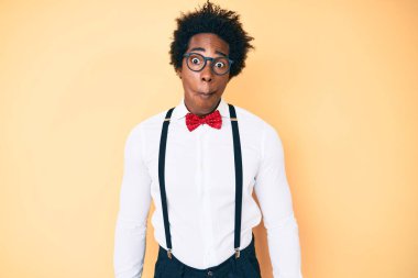 Afro saçlı, şık görünümlü, dudaklı, çılgın ve komik bir jest yapan yakışıklı Afro-Amerikan erkeği. Komik ifade. 