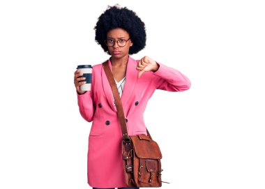 Deri çanta giyen ve kızgın yüzlü bir fincan kahve içen genç Afro-Amerikalı kadın. Negatif işaretler baş parmakları aşağıda, reddedilme kavramı. 