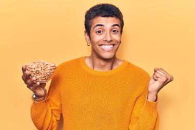 Yerfıstığı tutan Afrikalı genç bir Amerikalı gururla bağırıyor zaferi ve başarıyı kutluyor. 